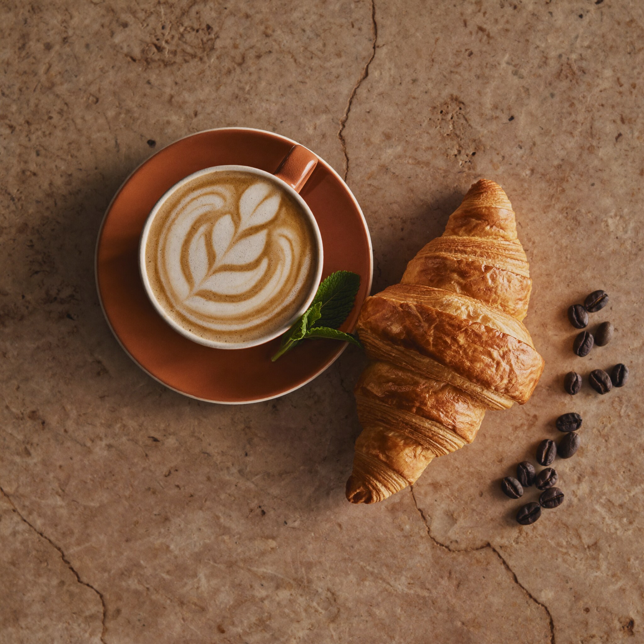 Cappuccino and croissant on stone